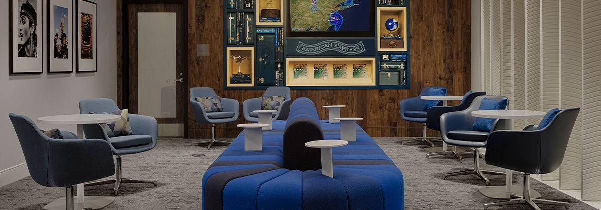 a room with a long blue couch and chairs
