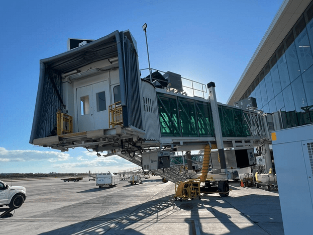 a large white passenger bridge with a large glass door
